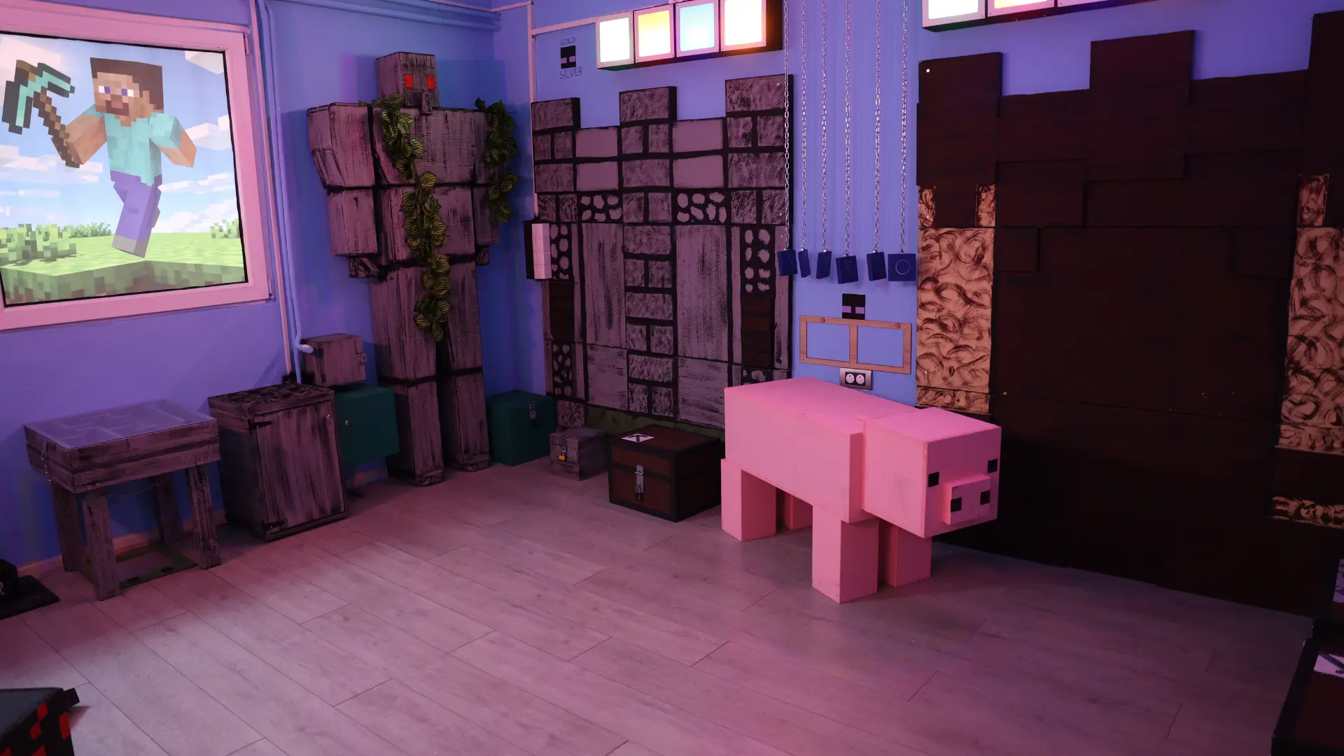 Unutrašnjost Majnkraft escape room sobe sa prikazom Stiva i njegovog pijuka, ružičastom kockastom svinjom, drvenim sanducima i zidovima sa blokovima u pikselizovanom stilu.
